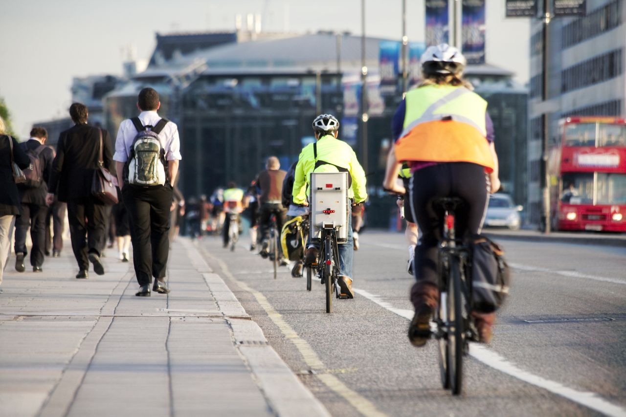 Commuters cycling to work on a road