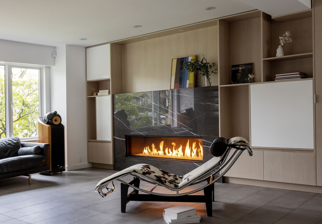 A modern living room with a fireplace and cow print lounge chair