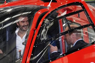 Prince William and David Beckham climbing into a red helicopter