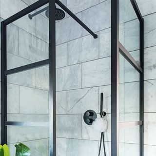 black shower enclosure with marble tiles