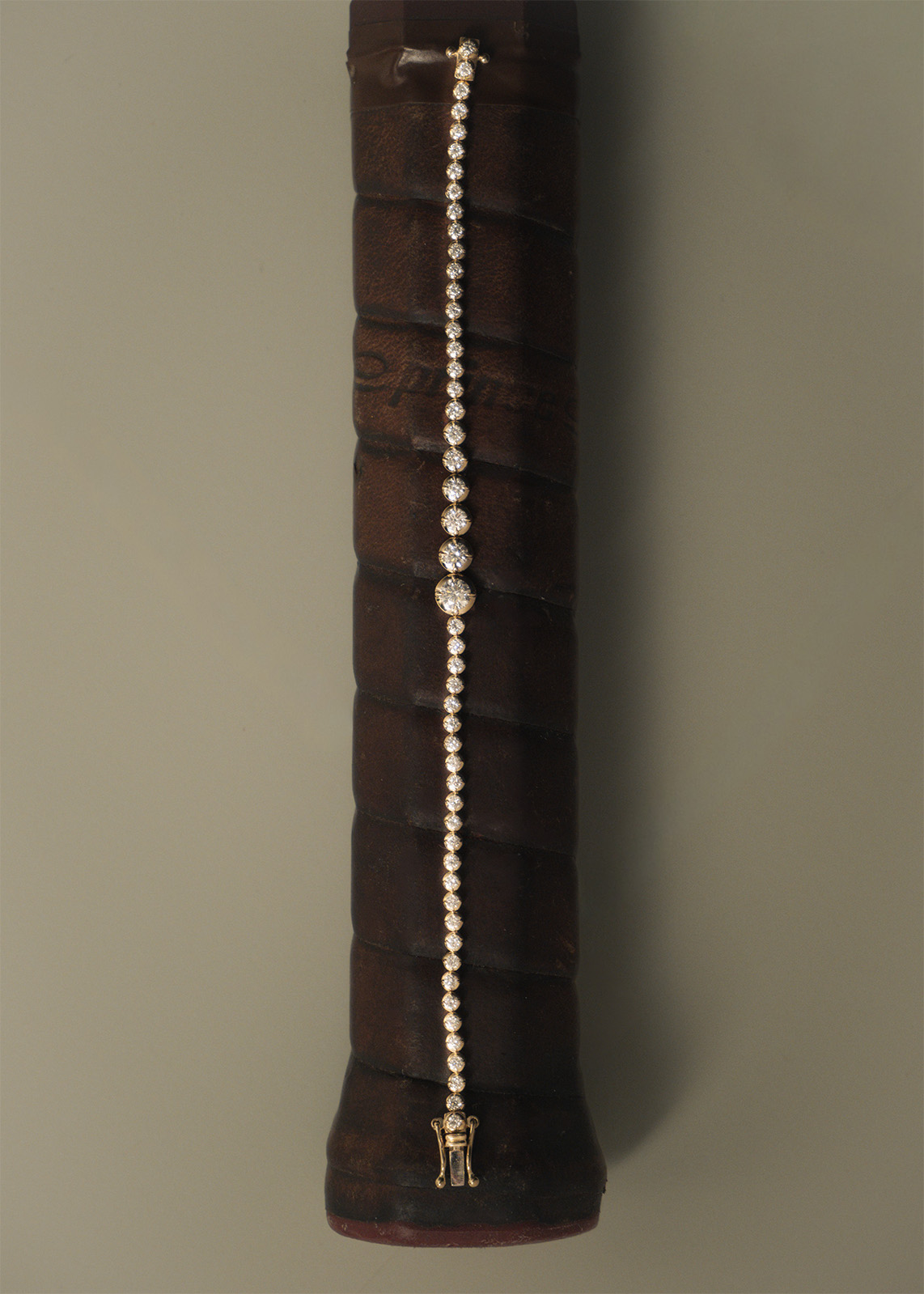 A new Kinn Studio bracelet from the Prince collaboration laid on a tennis racket.