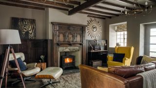 cottage living room with wood wall panelling and stove
