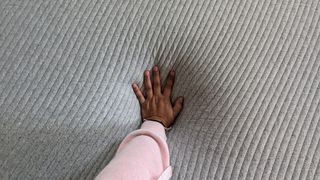 Casper Original mattress review, with our main tester's hand on the surface of the bed