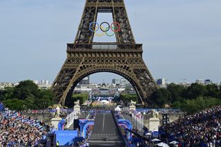 Kristen Faulkner crosses the line in front of the Eiffel Tower to take gold in the women's 2024 Olympic road race.