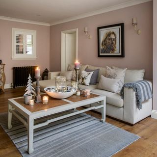 sitting area with wooden flooring and pink wall