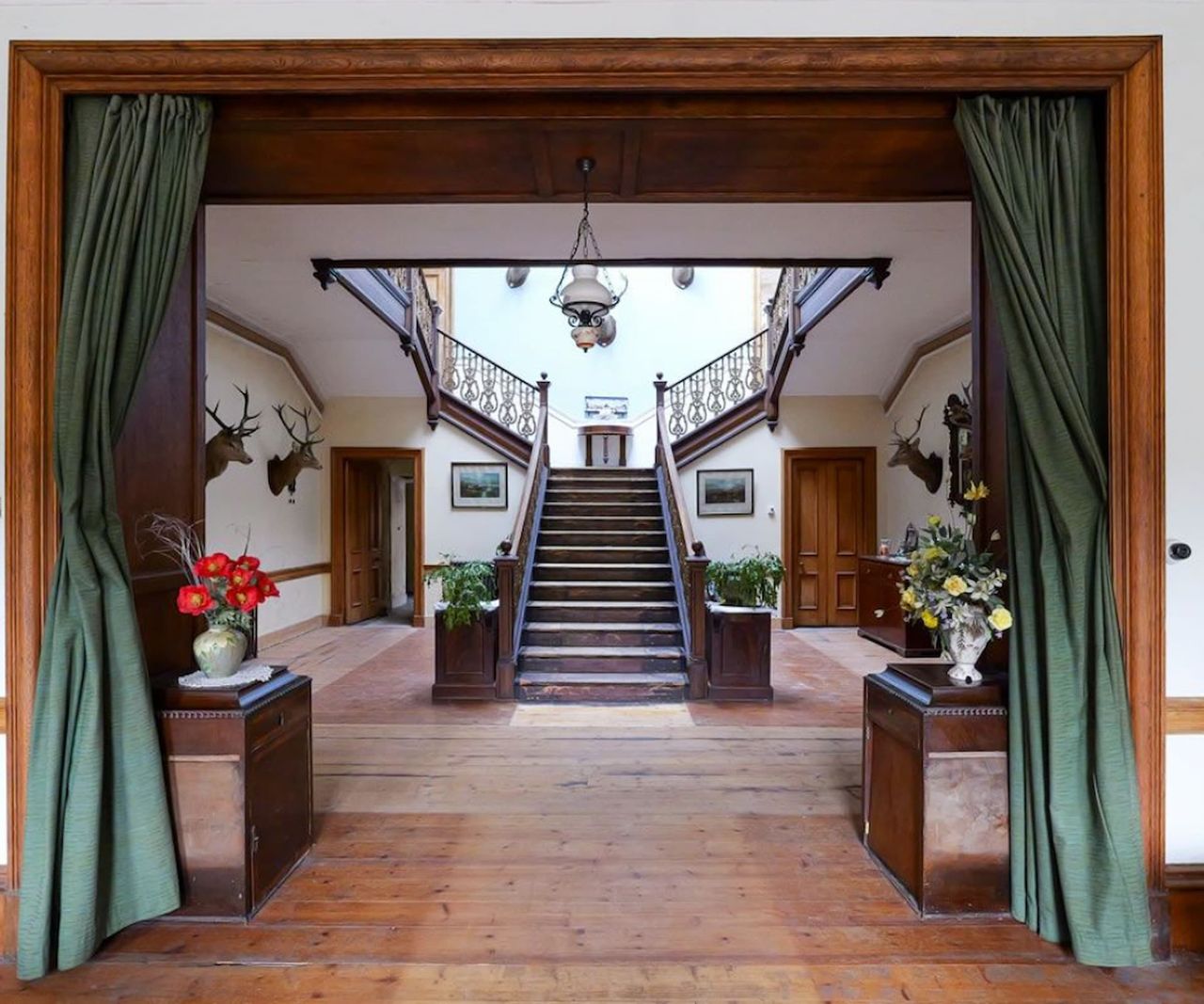 A wooden hallway and staircase with the staircase splitting in two directions, left and right