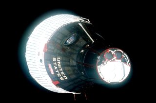 The Gemini 6A spacecraft as photographed from Gemini 7 on Dec. 15, 1965, including a "Beat Army" sign in the window.