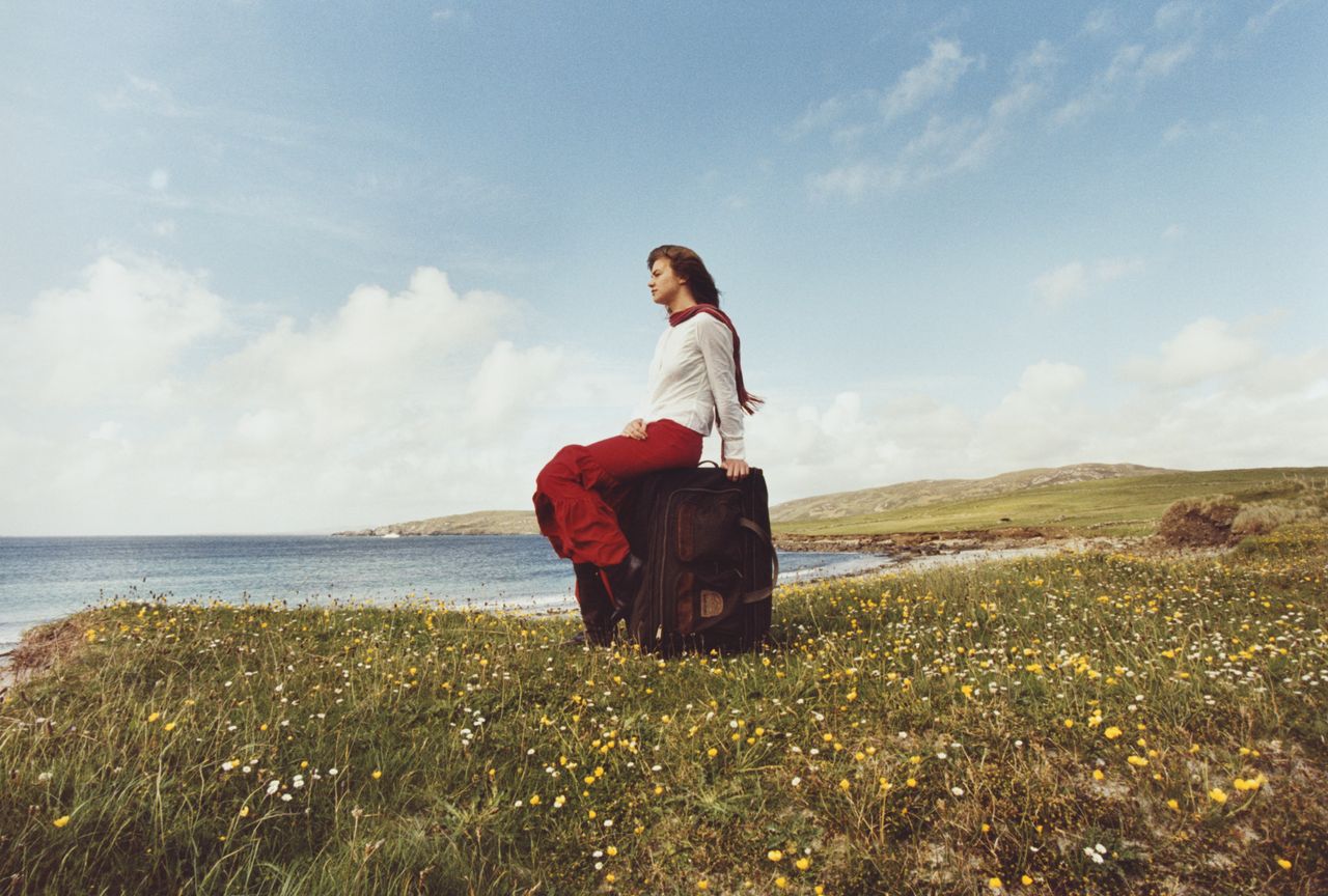 Woman sitting on a suitcase