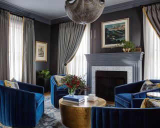 living room with gray walls, blue velvet armchairs and gray curtains