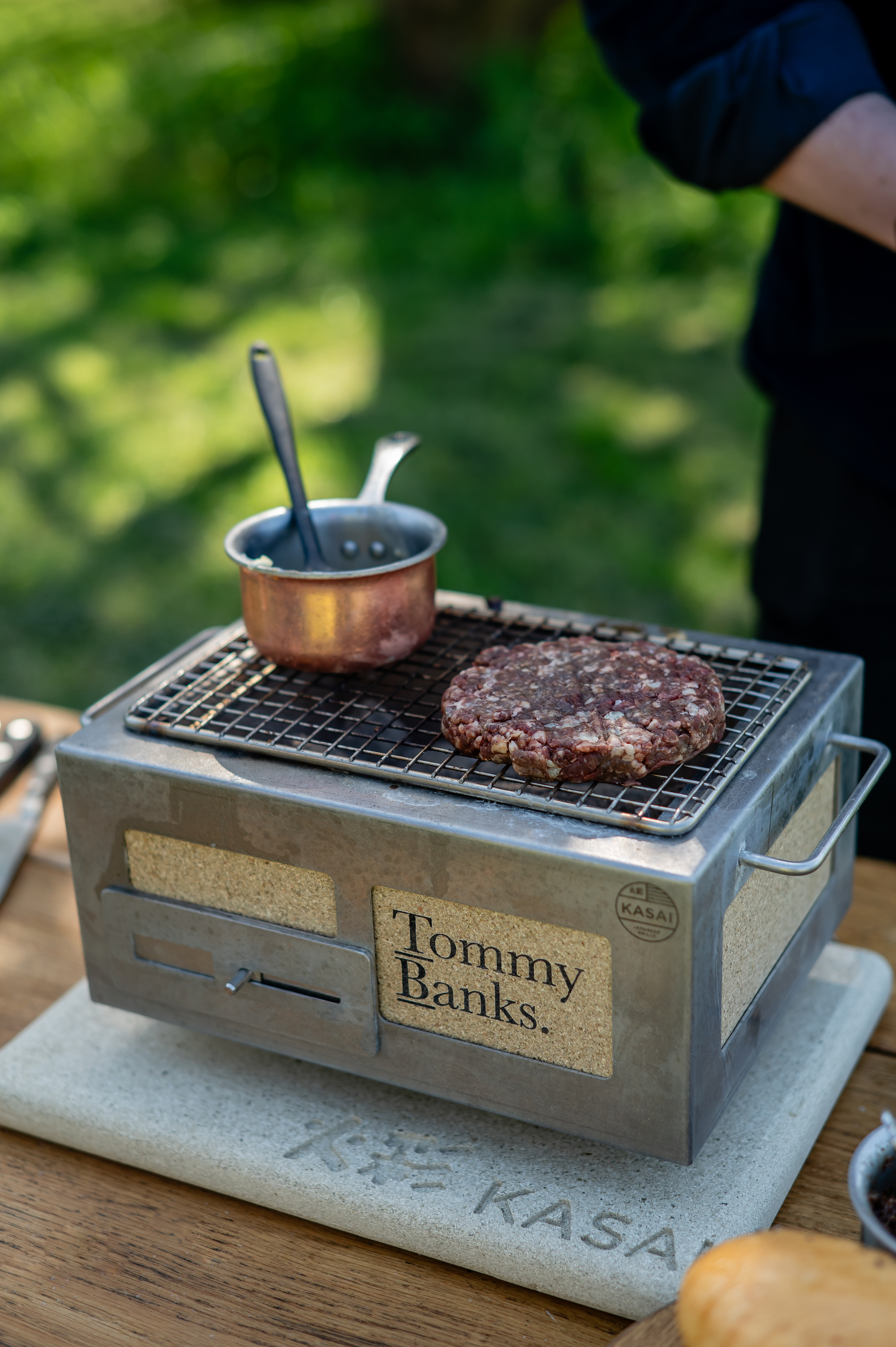 A steel Japanese bbq grilling a burger