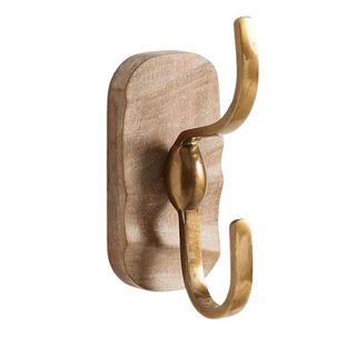 A gold hook mounted on wood