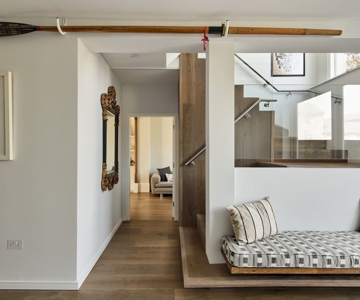 A wooden staircase with a seating area and wooden panel flooring