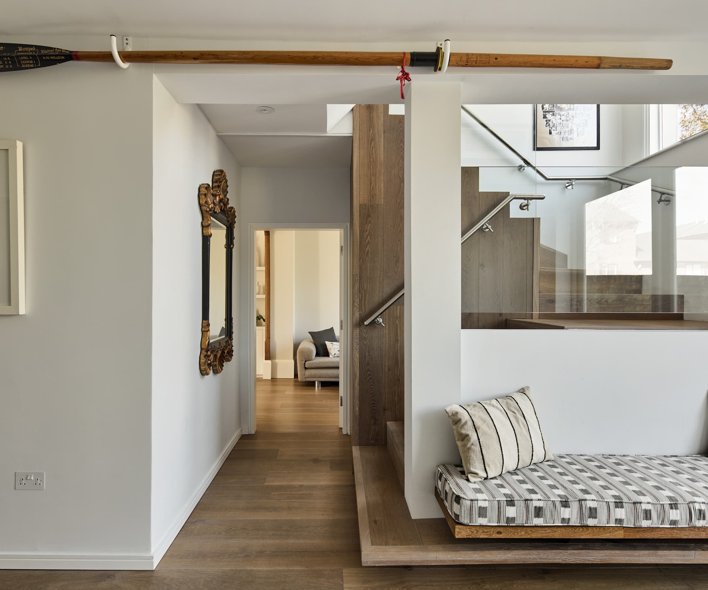 A wooden staircase with a seating area and wooden panel flooring
