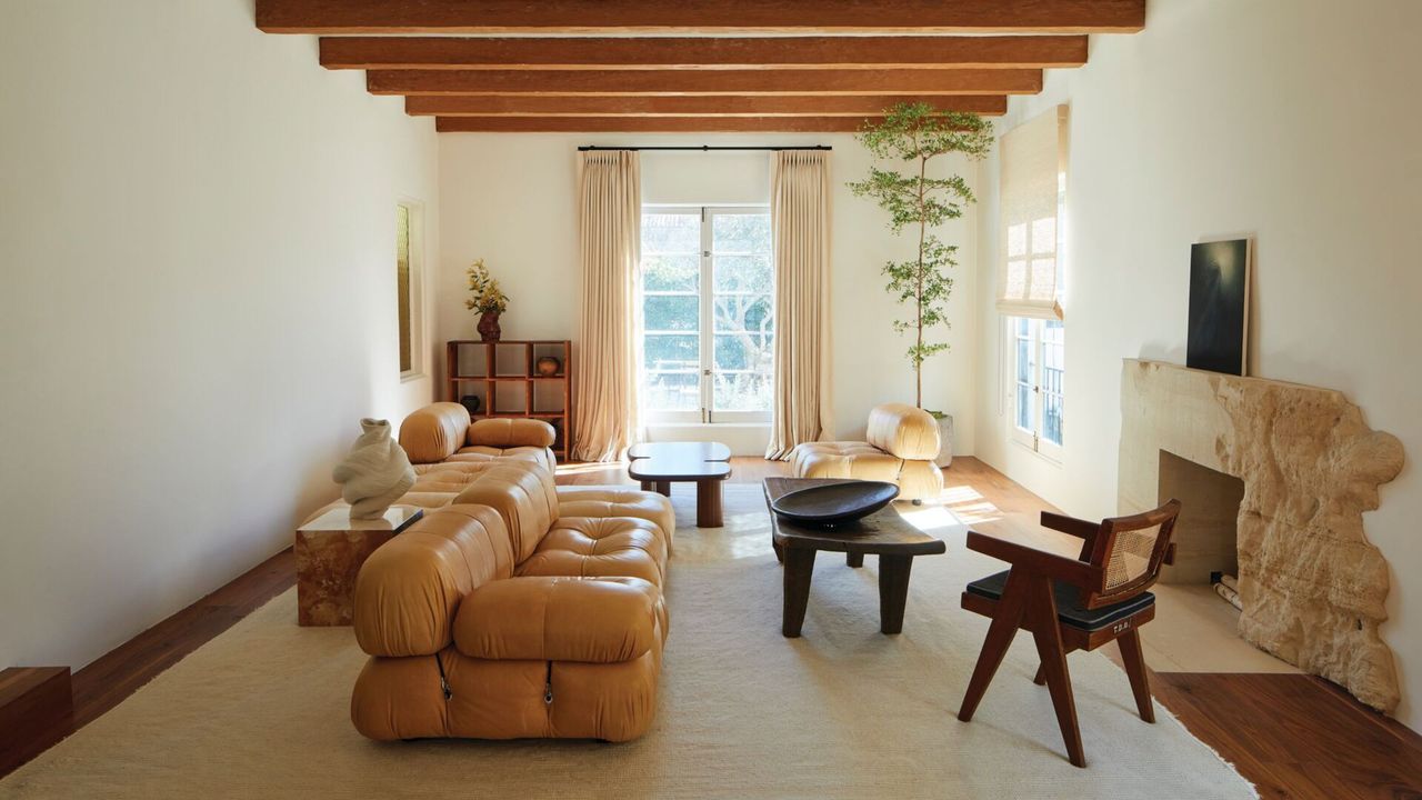 modern coastal-style living room with stone fireplace surround and exposed timber ceiling beams