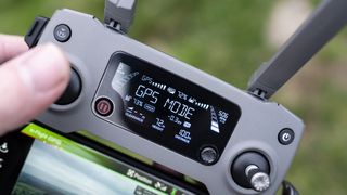 DJI drone controller showing GPS mode held in pilots hands