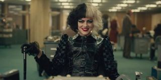 Emma Stone as Cruella in black and a cane in 2021 live-action movie