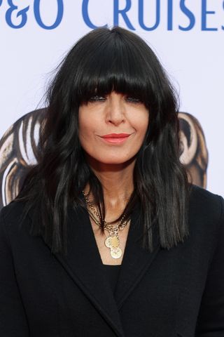 Claudia Winkleman smiling with black wavy bob with fringe