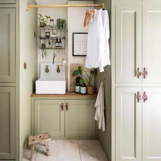 utility room/boot room with small sink and cleaning area complete with hanging rail for wet clothes