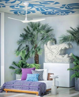 bedroom with palm trees and white and blue wallpaper on the ceiling