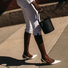 A woman in New York City wearing white slingback heels