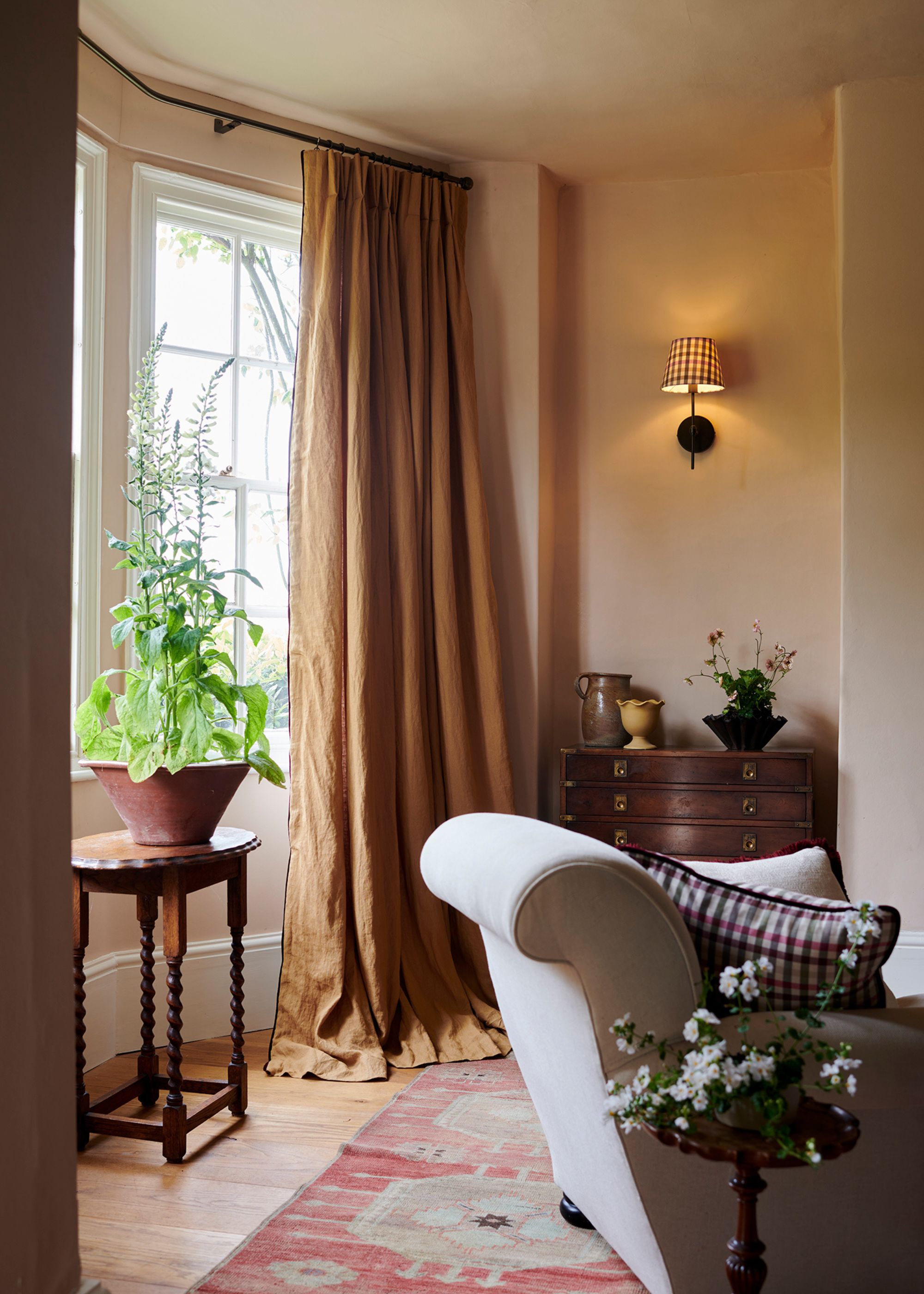 A neutral living room with heavy linen curtains in a warm light brown color.