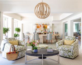 white living room with green floral upholstered chairs