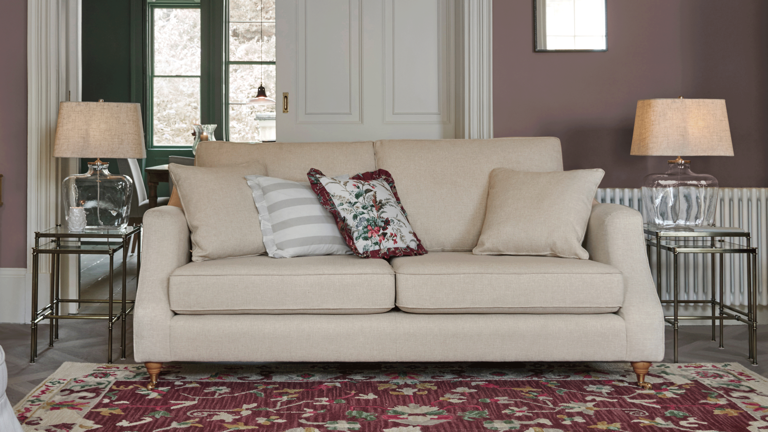 neutral living room with a sofa and wooden bobble based floor lamp with a neutral drum shade