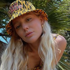 Woman looking into a camera in front of a palm tree