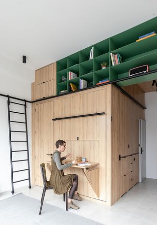 interior of qorner tower apartment with space-save raised storage and fold-away desk