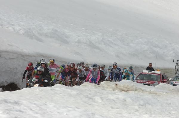 Riders ascend through deep snowbanks on the Gavia.