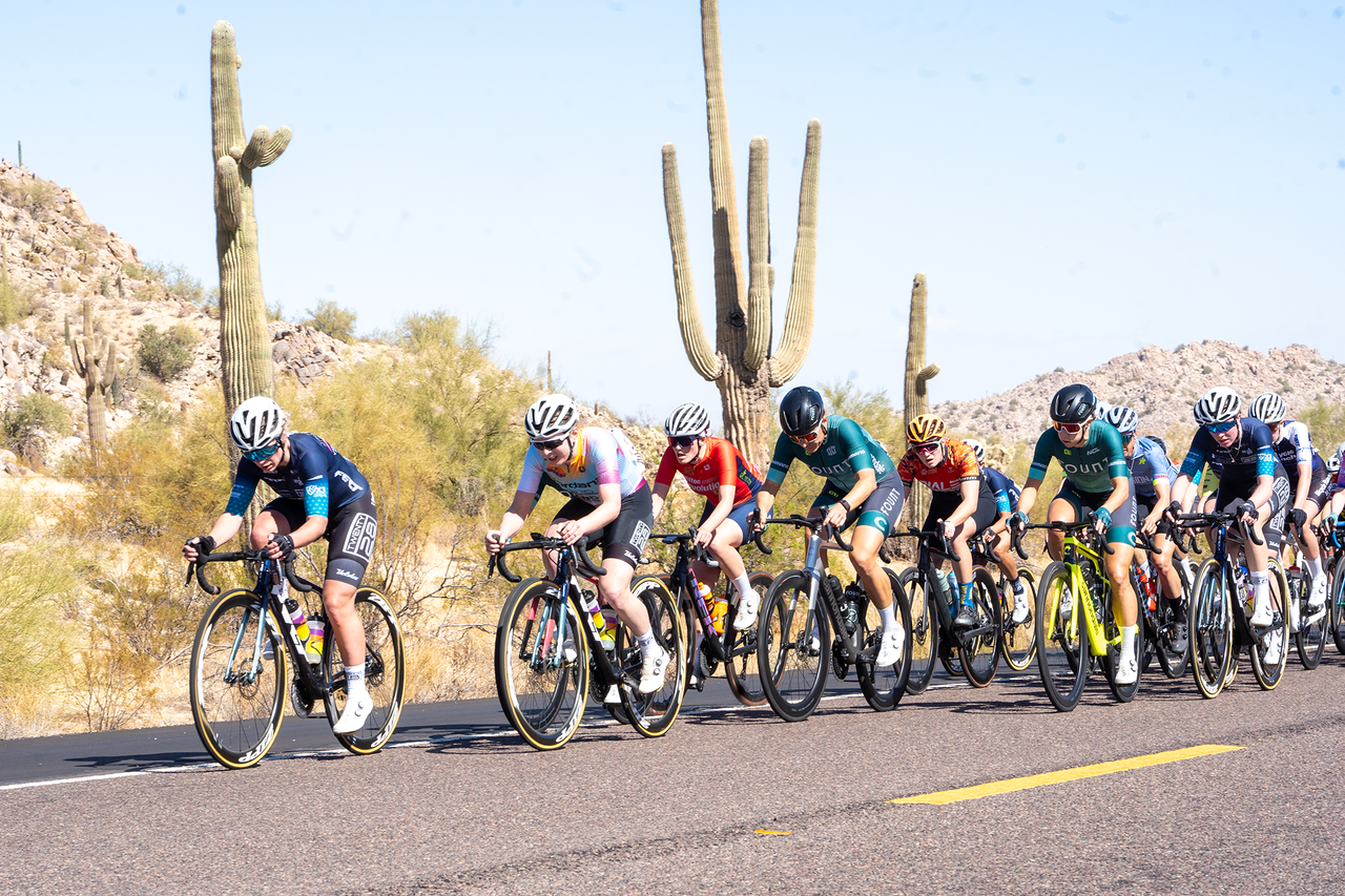 The elite women's field passing desert cacti on the 62-mile stage 2 road race in Casa Grande, Arizona