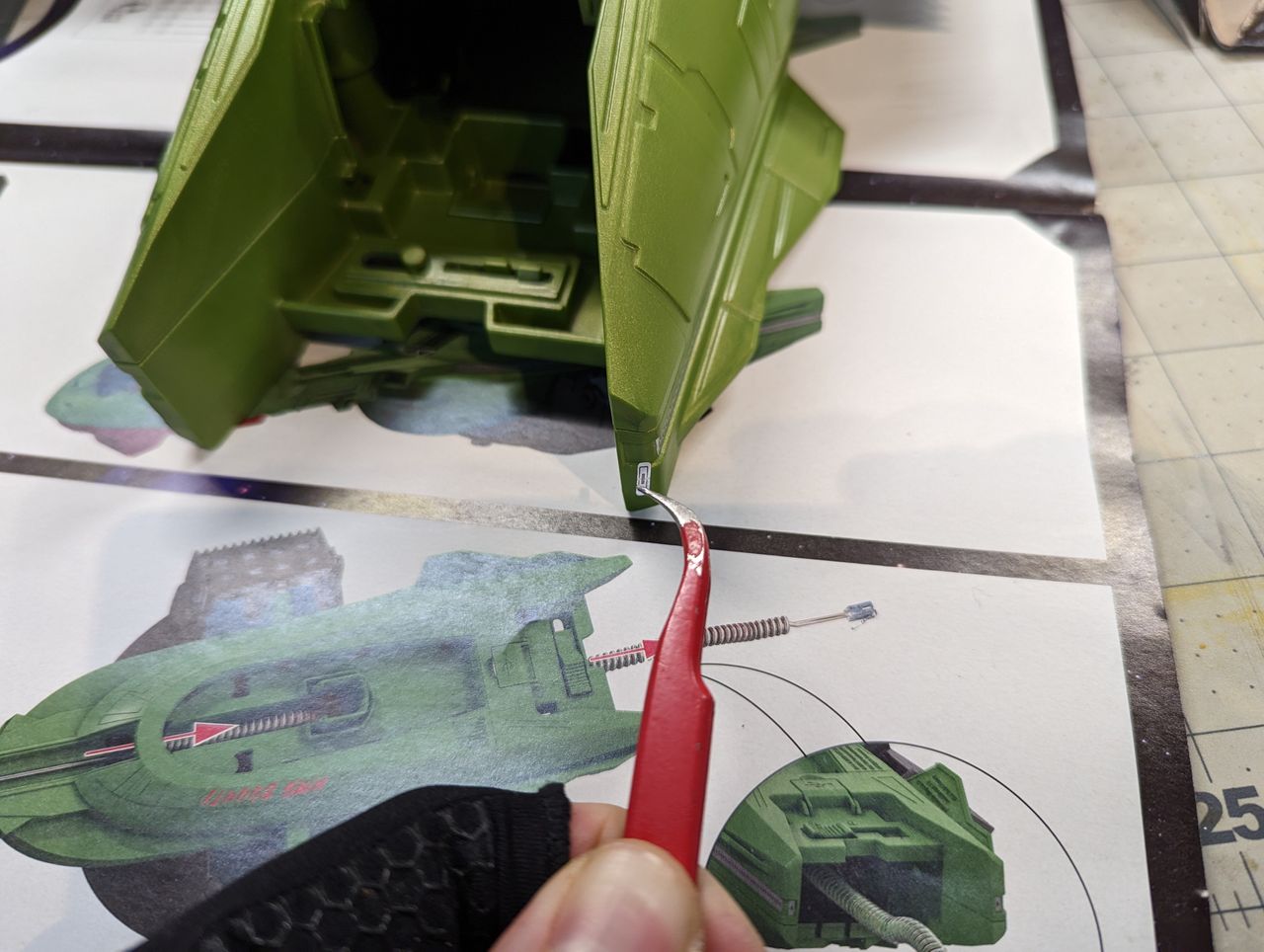 a child assembles a klingon bird of prey on a workbench