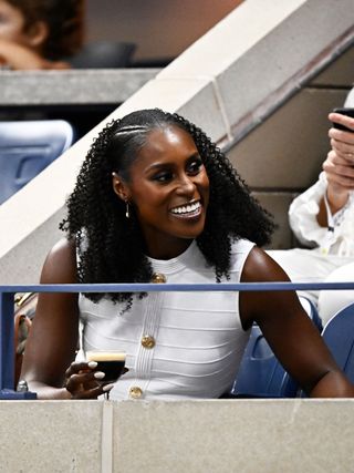 Issa Rae attends the 2024 US Open wearing a white dress and sitting in the Grey Goose suite