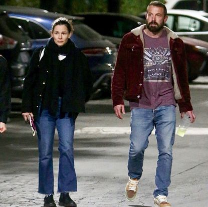 Jennifer Garner and Ben Affleck wearing coats and jeans walking through a parking lot at night