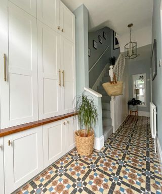 A hallway with printed floor tiles and a long white cabinet made with Ikea products