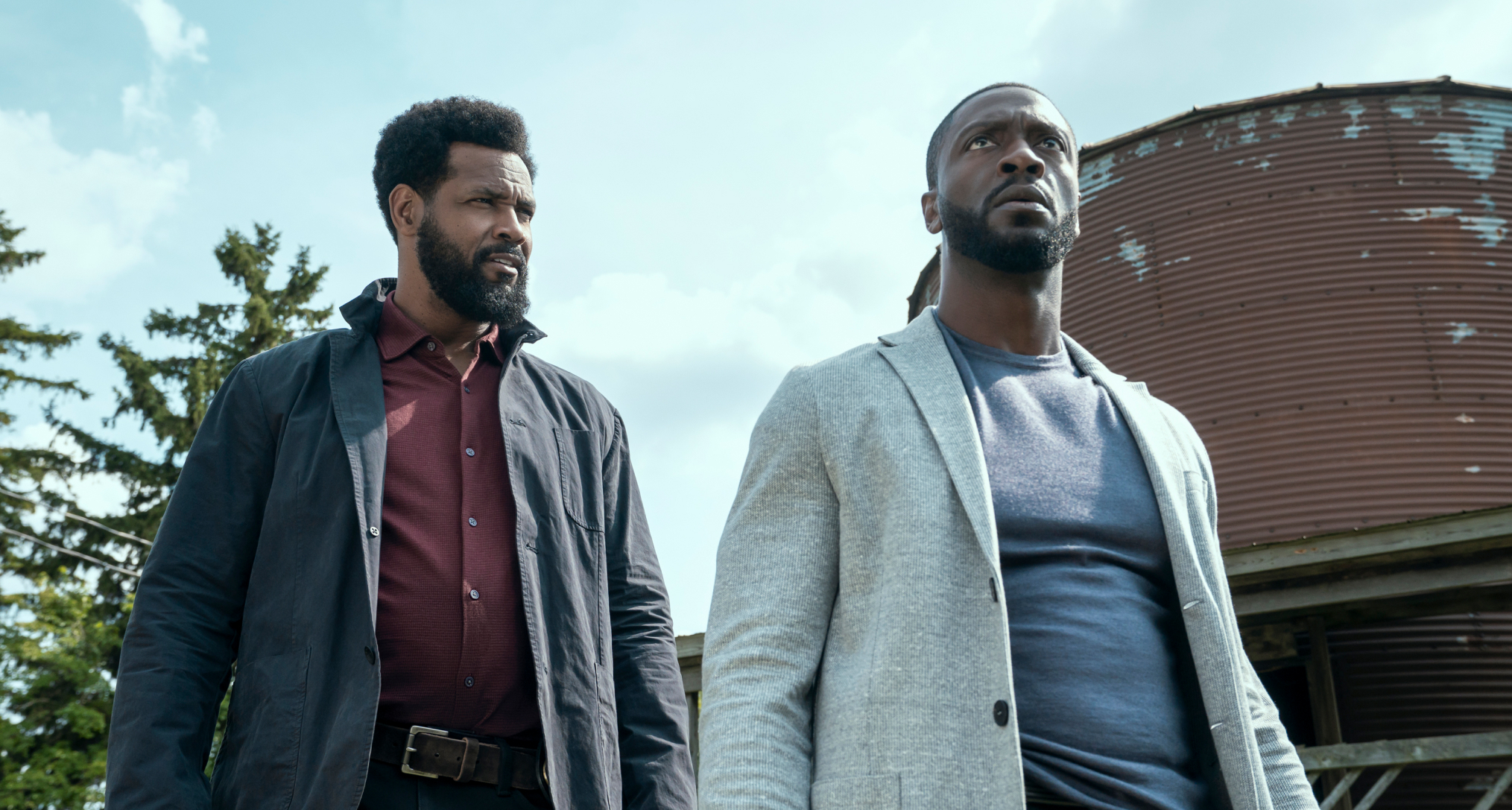 John Sampson (Isaiah Mustafa) and Alex Cross (Aldis Hodge) walk outdoors in front of a water tower in the cross season 2 finale