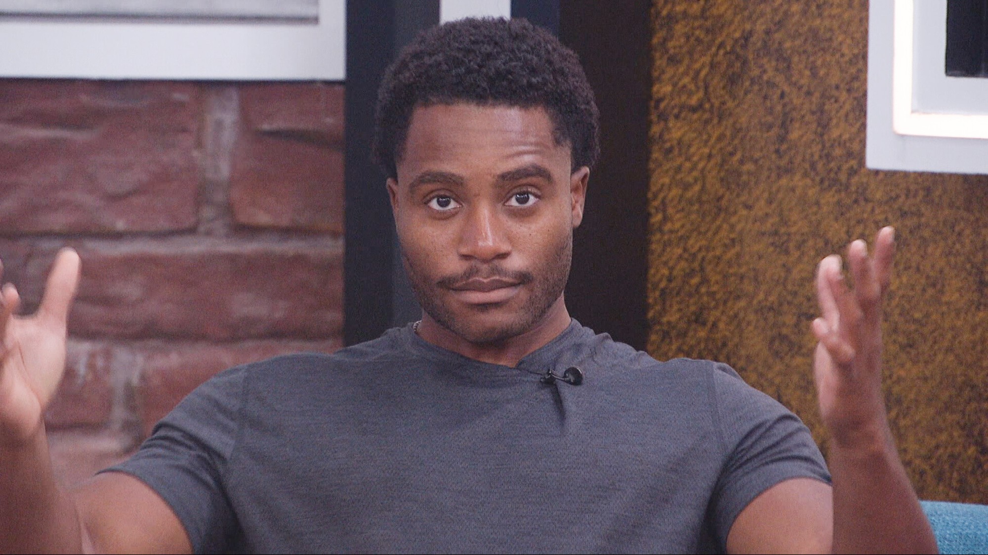 Chuk throwing his hands up in dismay in the Big Brother house. 