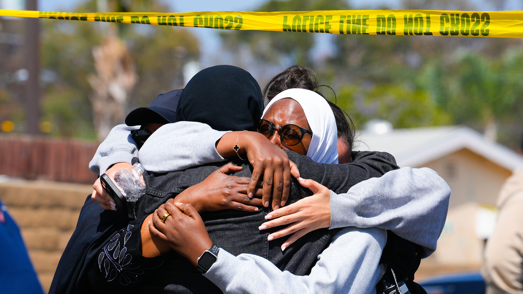 Several people embrace one another following a deadly shooting at a mosque in San Diego, USA