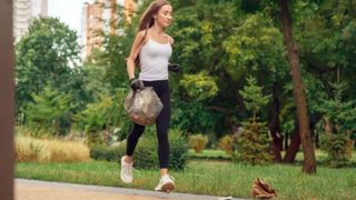 a woman running with a bin bag in one hand