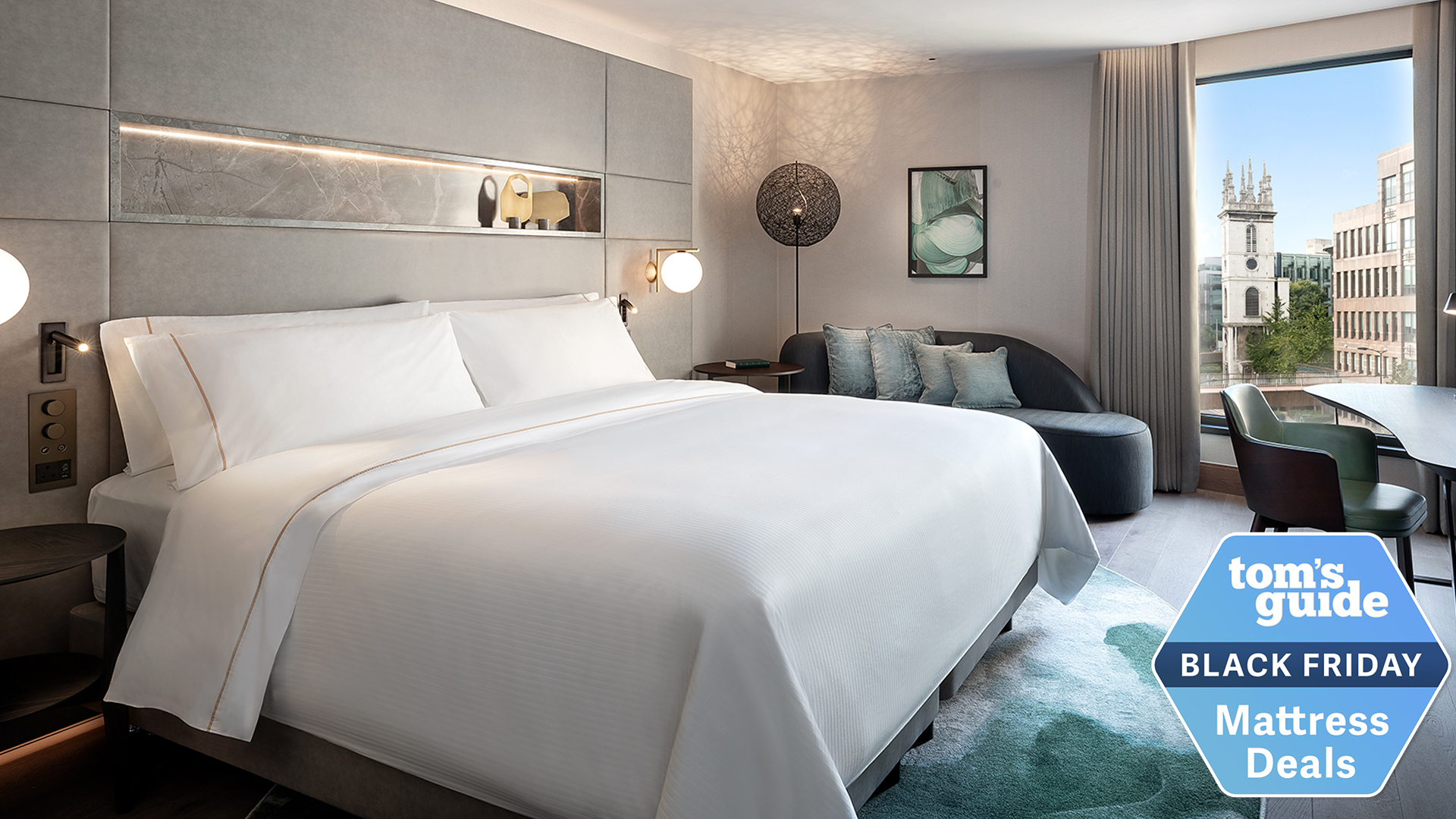 A neatly made bed in a suite with the Tom's Guide Black Friday mattress deals badge