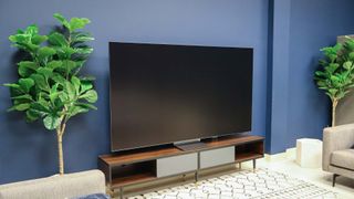 A Samsung QN990F on a TV stand.