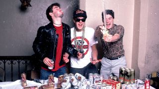 A photograph of Beastie Boys spraying each other with beer, taken in 1987