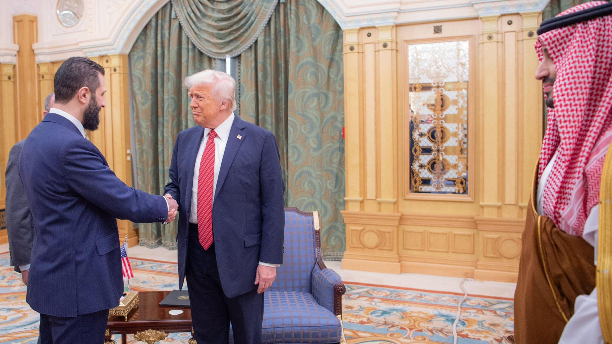 Saudi Crown Prince Mohammed bin Salman, right, looks on as U.S. President Donald Trump, center, shakes hands with Syrian Interim President Ahmed al-Sharaa, left, in Riyadh
