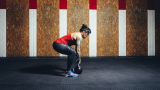 Woman performing deadlift with kettlebell
