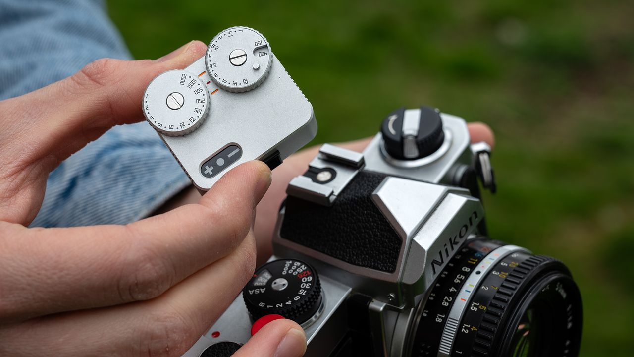 Close-up of TTArtisan Light Meter II on a Nikon FM being held out in the field