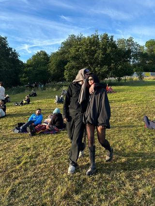 Dua Lipa wearing a sporty jacket and hot pants at Glastonbury with Callum Turner.