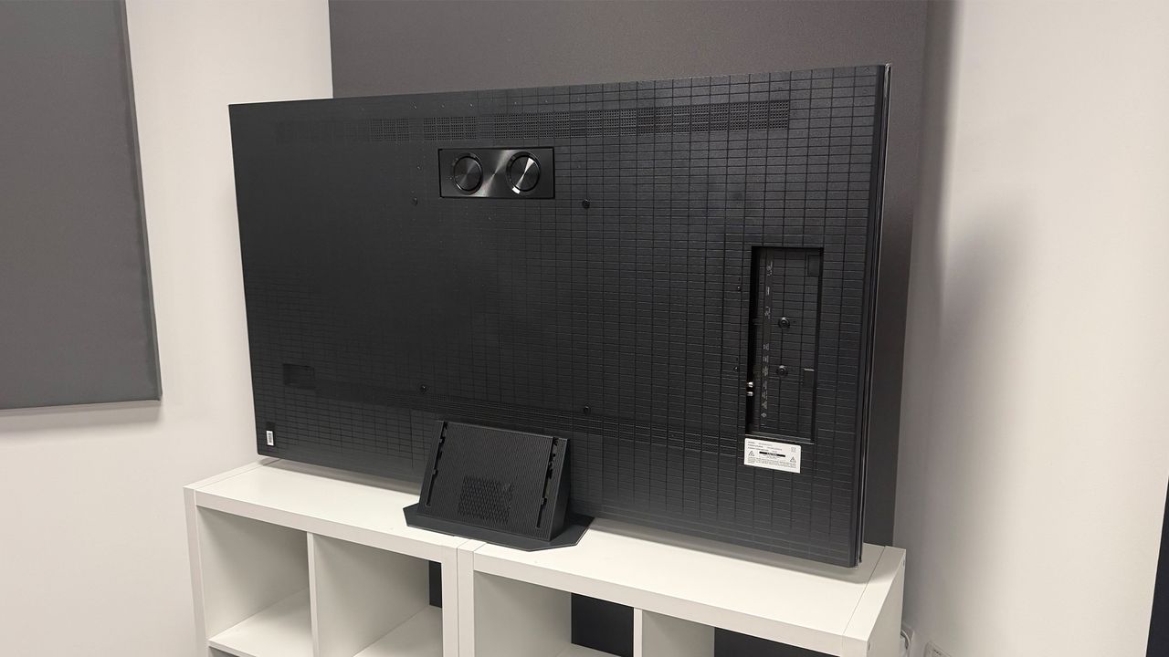 The 65-inch Hisense UR9 RGB Mini LED TV, photographed on a white, wooden unit. On the screen is a still from Netflix documentary, The Dinosaurs.