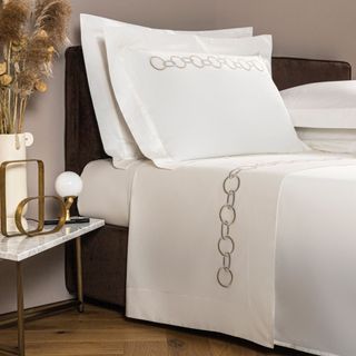 Frette Links Embroidery Sheet Set on a bed.