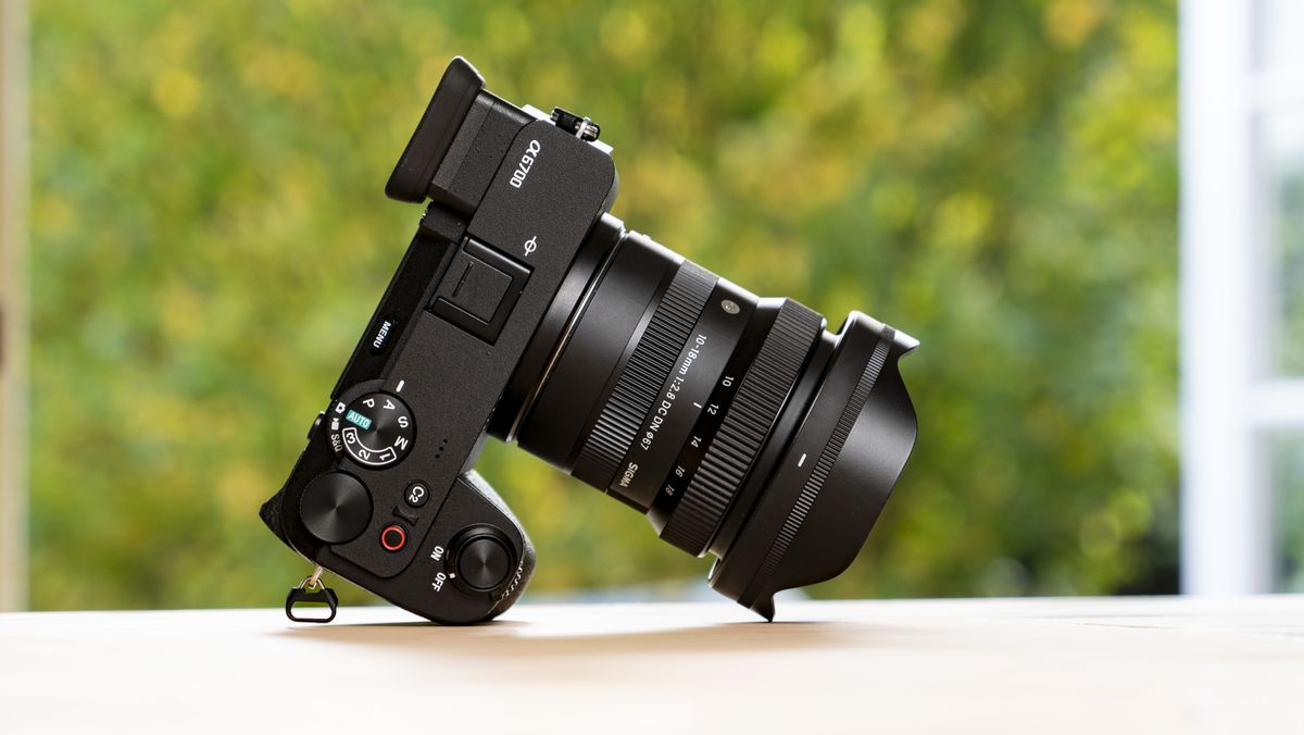 Sigma 10-18mm f/2.8 DC DN lens mounted to a Sony A6700 on a wooden table