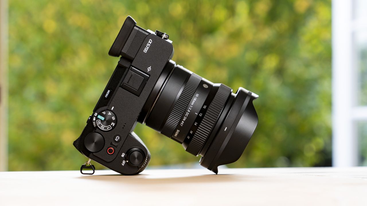 Sigma 10-18mm f/2.8 DC DN lens mounted to a Sony A6700 on a wooden table